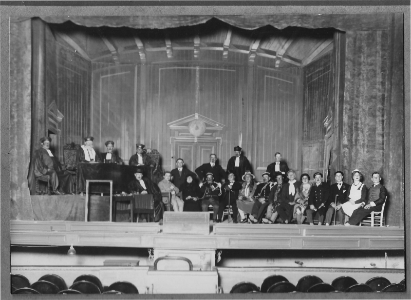 La troupe jouant Lous Proufitaires, sans doute au théâtre de Béziers, en 1932-1933 (date figurant au dos de la photo). Cette photo inédite nous a été aimablement communiquée par Jany Audouy, des « Amis de Nissan », dont le grand-père, Léon Lignon, est le cinquième acteur en partant de la droite (habillé en femme). La plupart des acteurs sont Nissanais. Au centre, entre deux gendarmes, on reconnaît les deux personnages dont la pièce représente le procès, les époux Ventredor. Derrière eux se tient l’auteur, Émile Barthe. 